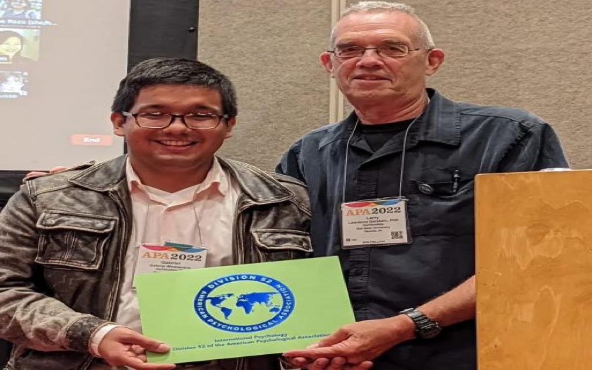 El presidente saliente de la División 52 de la APA, Dr. Lawrence Gerstein, entrega certificado de reconocimiento  al estudiante Gabriel L. Medianero Araúz. 